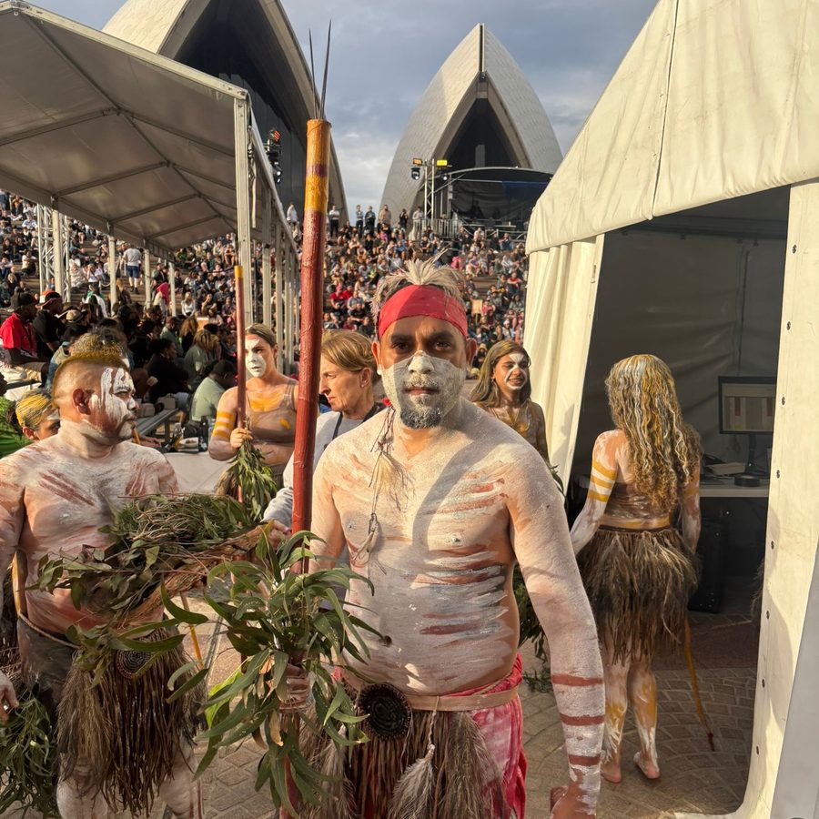 Ryka Ali holding a spear and gum leaves at the Sydney Opera House forecourt